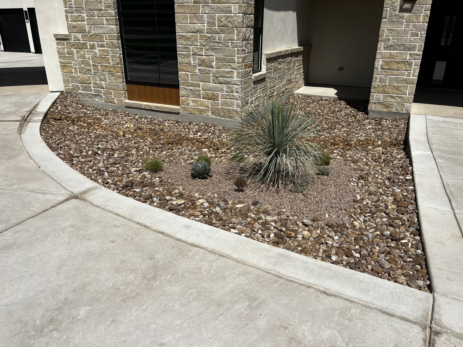 Yucca and gravel bed beside stone house