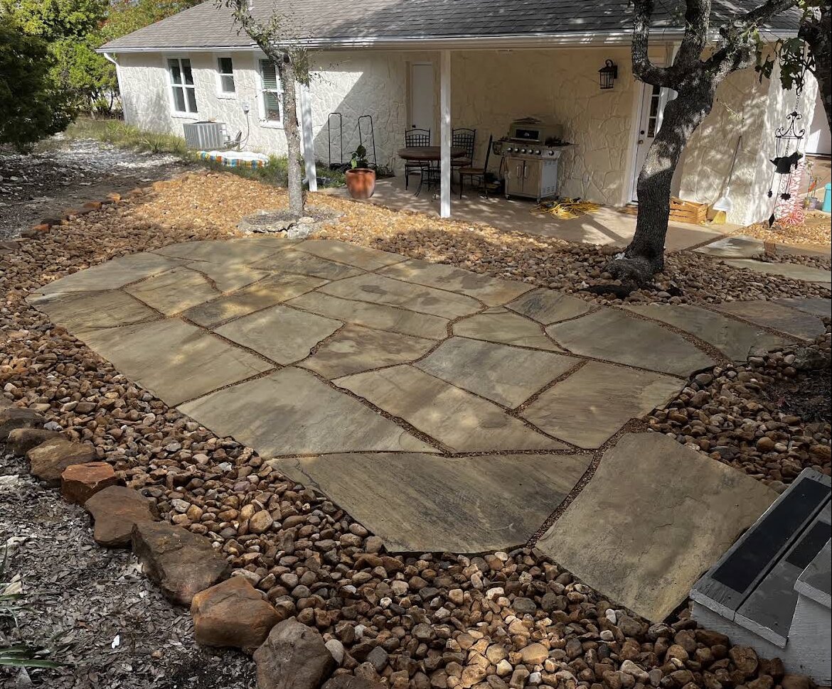 flagstone patio with river rock bed toward house porch